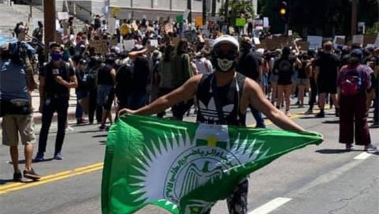 Un homme brandissant le drapeau du Raja lors des manifestations réclamant justice pour la mort de l'Afro-Américain George Floyd.
