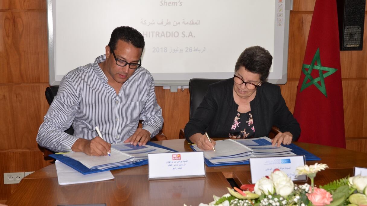 Younes Boumehdi président de Hit Radio et Amina Mrini, présidente de la HACA en pleine signature du cahier des charges.
