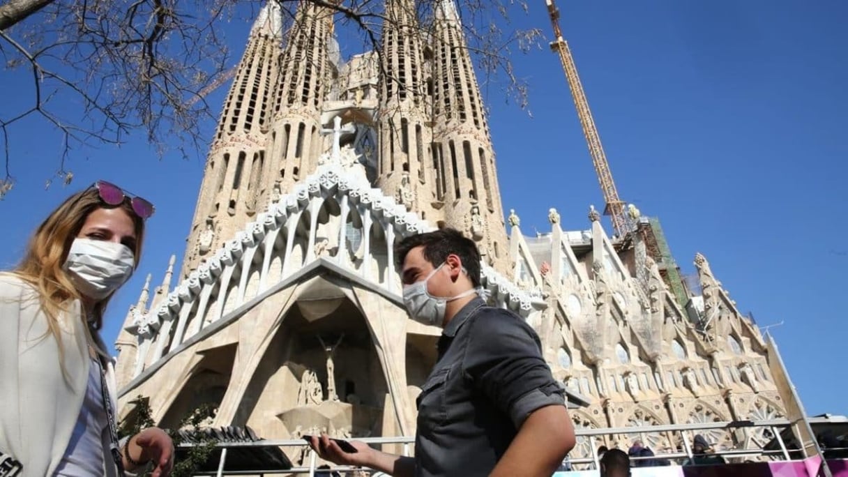 Deux Barcelonais portant un masque de protection contre le coronavirus, dans l'une des places de la capitale de la région espagnole de Catalogne. 
