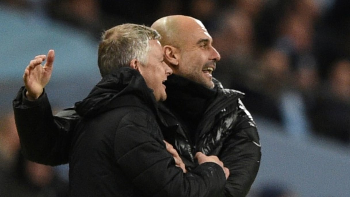 L'entraîneur de Manchester United, le Norvégien Ole Gunnar Solskjaer (à gauche) et son homologue de Manchester City, l'Espagnol Pep Guardiola (à droite), lors d'un match de Championnat d'Angleterre entre les deux clubs à l'Etihad Stadium le décembre 2019.
