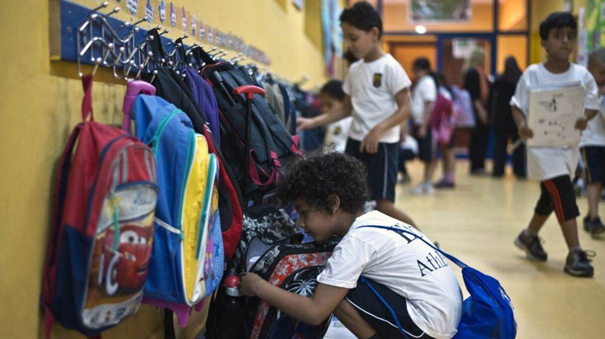 Farris Hamid, 6 ans, ouvrant son cartable dans le hall de l'Egypt British International school, Le Caire, Egypte 
