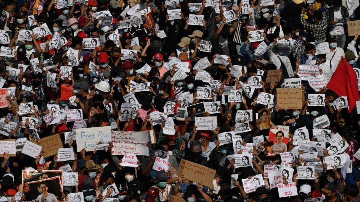 Des centaines de manifestants tiennent des pancartes demandant la libération de la dirigeante birmane détenue Aung San Suu Kyi, lors d'une manifestation contre le coup d'Etat militaire à Rangoun, le 9 février 2021.
