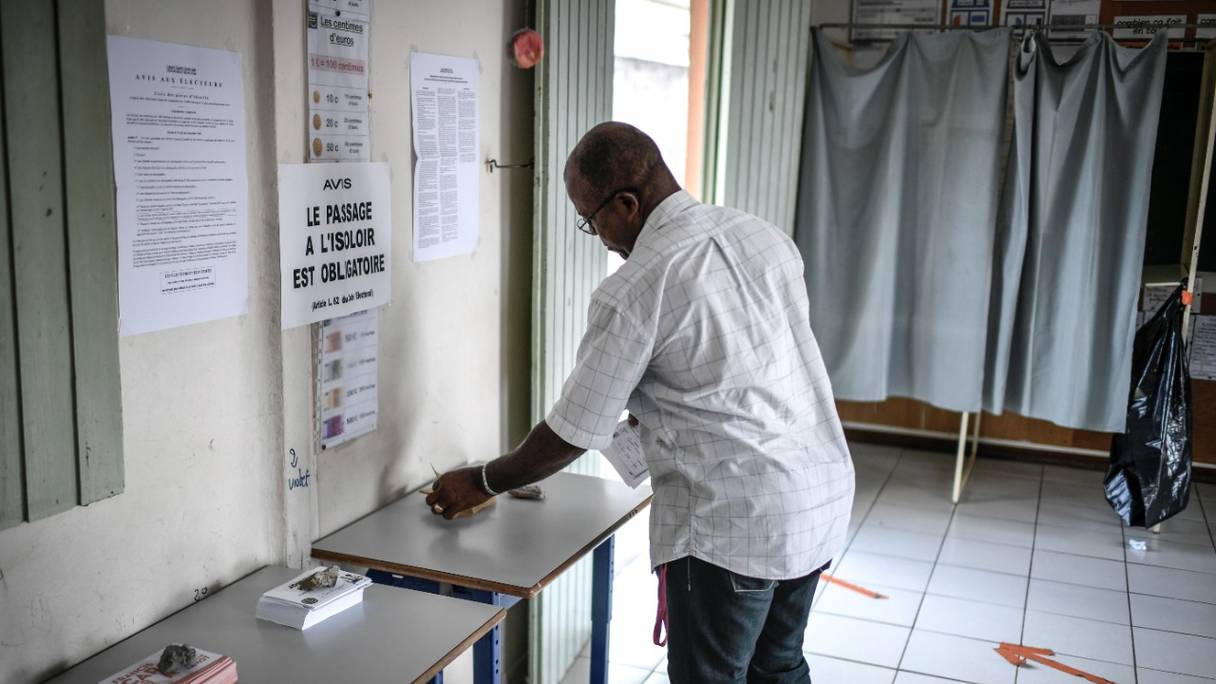 Un électeur se prépare à voter pour le second tour des élections législatives françaises dans un bureau de vote à Fort-de-France, sur l'île française de la Martinique, dans les Caraïbes, le 18 juin 2022.
