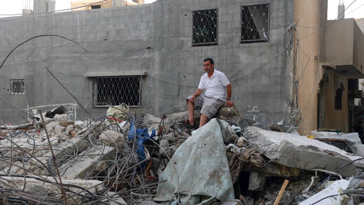 Un Palestinien est assis sur les décombres d'un immeuble, à la suite de frappes aériennes israéliennes à Rafah, dans le sud de la bande de Gaza, le 7 août 2022.
