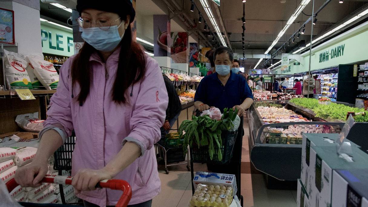 Des personnes font leurs courses dans un supermarché de Pékin, le 25 avril 2022. Les craintes d'un confinement à cause du Covid ont déclenché des achats de panique et de longues files d'attente se sont formées le 25 avril pour des tests en masse ordonnés par les autorités.
