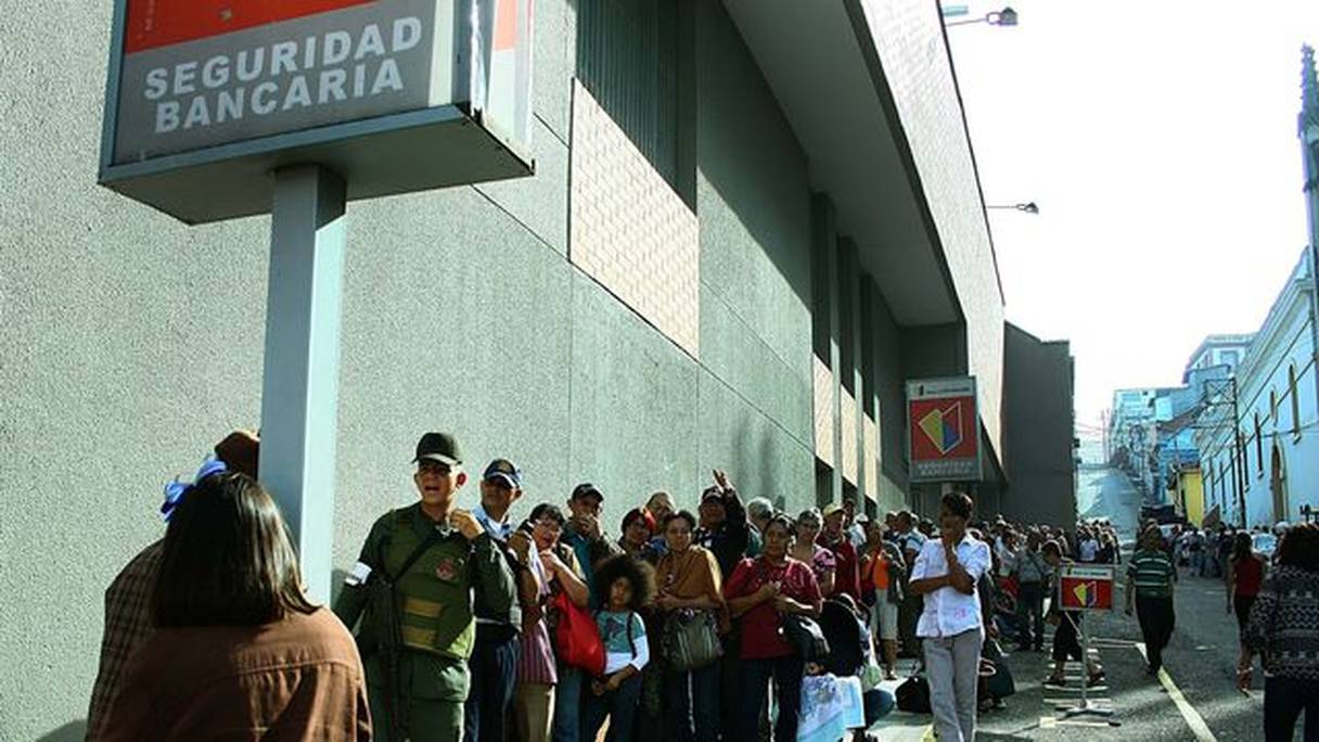 Des Vénézueliens font la queue devant une banque pour rendre des coupures bientôt dépourvues de valeur.
