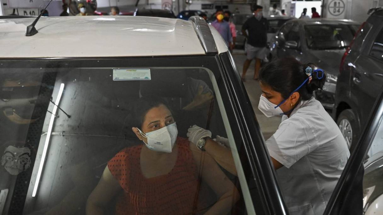 Une femme se fait vacciner avec une dose de vaccin Covishield d'AstraZeneca contre le coronavirus Covid-19 dans un centre de vaccination au volant, à Bombay, le 4 mai 2021.
