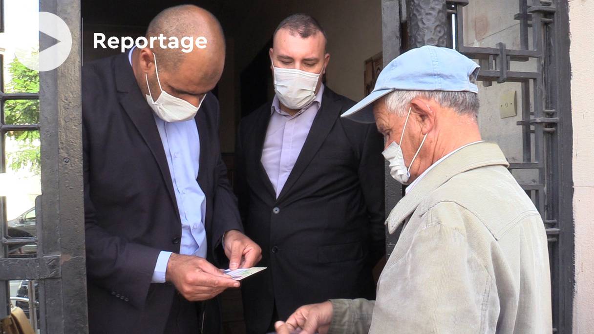 Des fonctionnaires vérifient la validité du pass sanitaire d'un usager des services de la commune urbaine d'Oujda, le 21 octobre 2021. 
