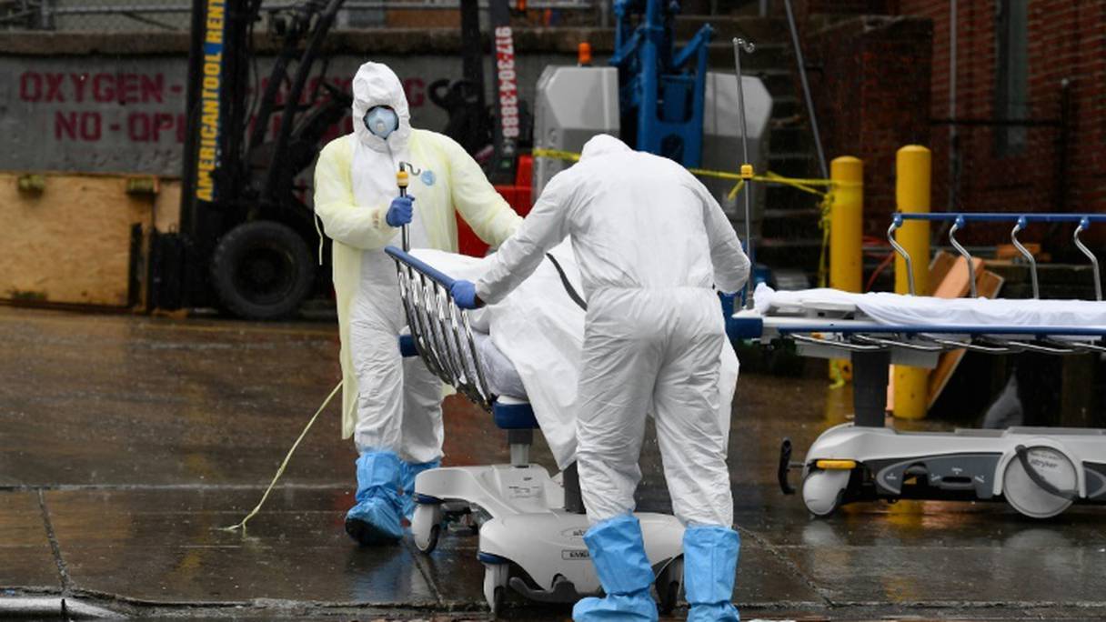 Du personnel médical transportent un mort du coronavirus dans un camion réfrigéré au Brooklyn Hospital Center, le 9 avril 2020.
