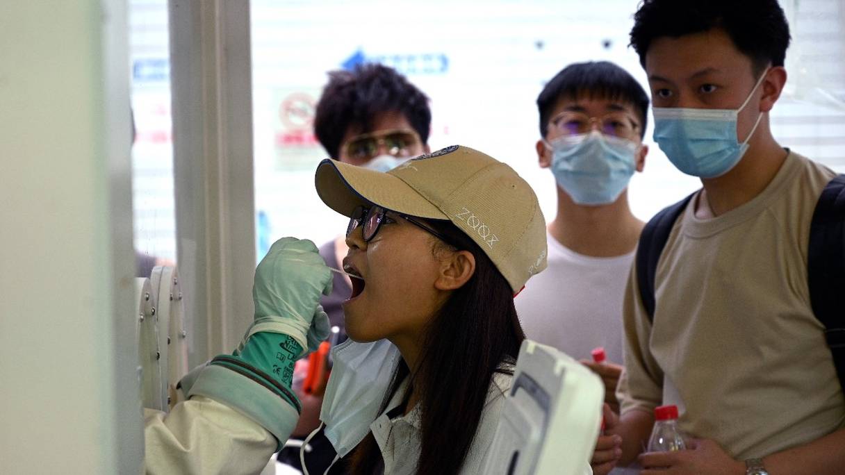 Un échantillon est prélevé sur une femme pour être testé pour le coronavirus Covid-19 dans un hôpital de Pékin, le 2 août 2021, alors que l'épidémie se répand pour la première fois dans le pays depuis des mois.
