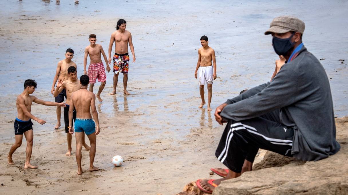 Des baigneurs se rassemblent par temps chaud sur une plage le long de la côte de la ville de Salé, au nord de Rabat, le 25 juin 2020. 
