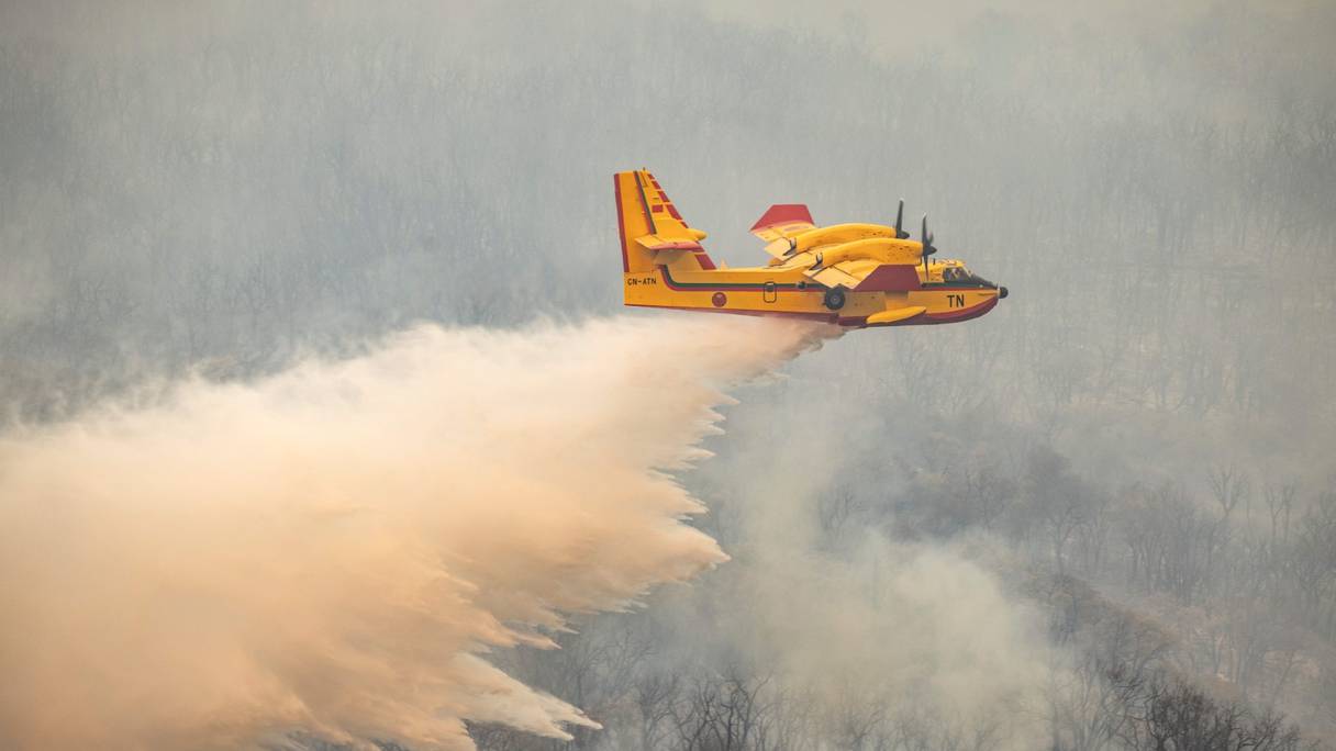 Un Canadair CL-415 des Forces royales air en action pour éteindre un feu de forêt qui fait rage près de la ville marocaine de Ksar el-Kebir dans la région de Larache, le 15 juillet 2022. 
