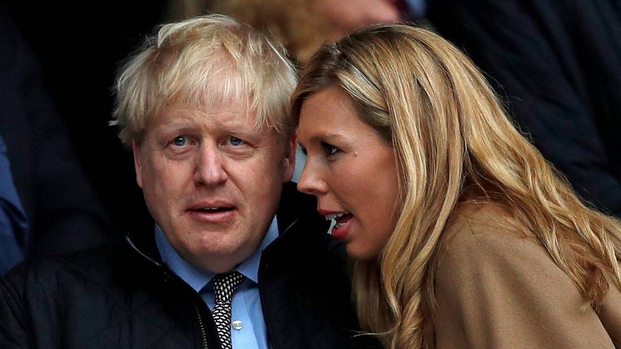 Le Premier ministre britannique Boris Johnson et Carrie Symonds, qu'il a épousée en secret le 29 mai 2021, assistent au match international de rugby des Six Nations entre l'Angleterre et Pays de Galles à Twickenham, à l'ouest de Londres, le 7 mars 2020. 
